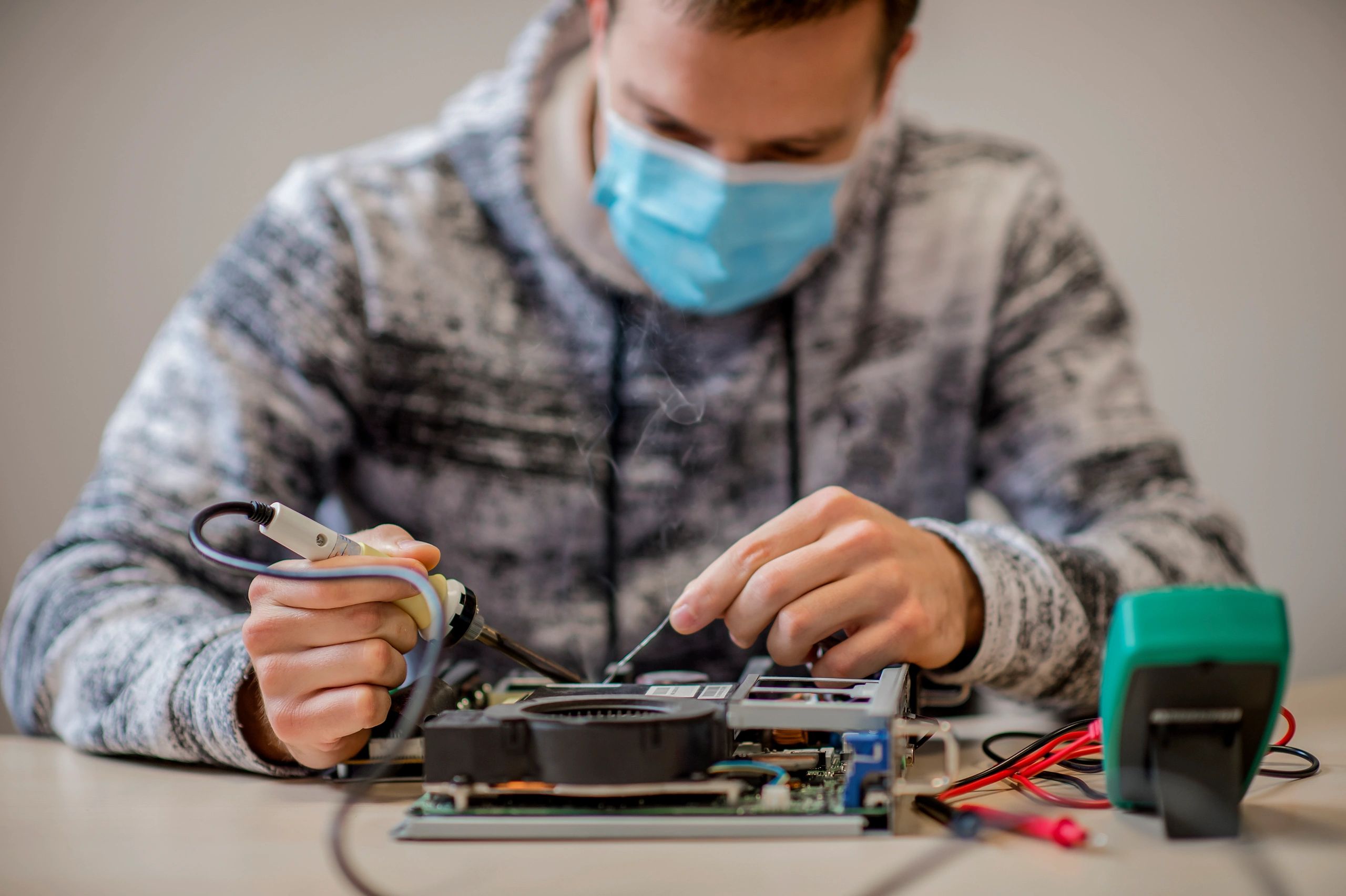 Ingeniero electrónico reparando una tarjeta electrónica en laboratorio